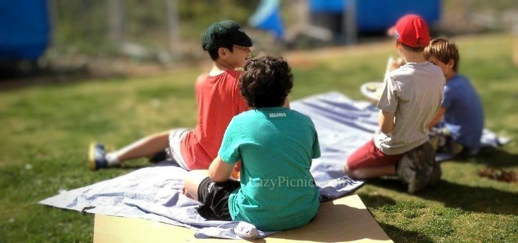 Children eating sandwiches at a a family picnic