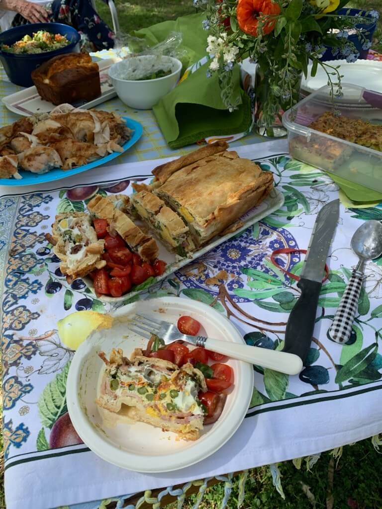 A table of delicious picnic food, including egg and bacon pie