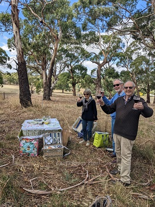 Picnic friends sending cheers while setting up for the picnic.