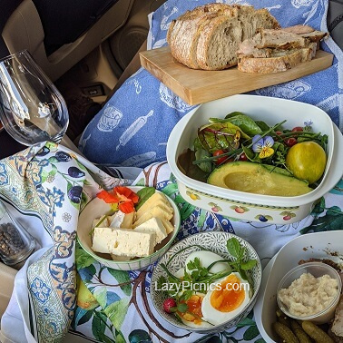 Picnic spread for two in front of a car.