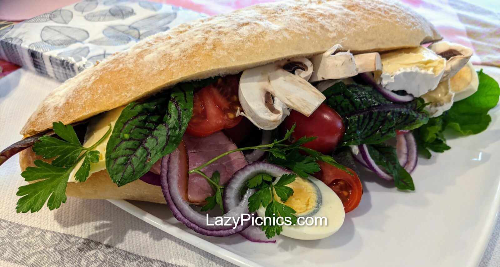 A small loaf of bread full of salad for a picnic.