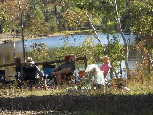A family group relaxing at a picnic by a lake