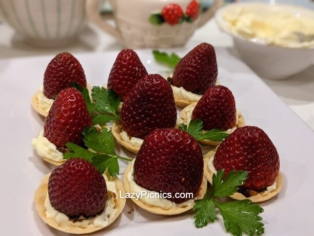 Strawberries sitting on the tarts ready to go.